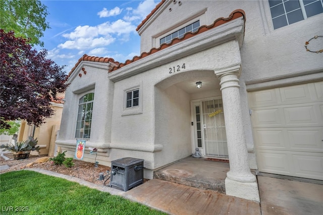 2124 Rising Mist St, Las Vegas, NV 89134 - doorway to property featuring a tile roof, stucco siding, and a garage