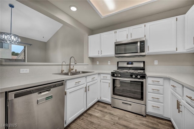 2124 Rising Mist St, Las Vegas, NV 89134 - kitchen featuring appliances with stainless steel finishes, a sink, vaulted ceiling, white cabinets, and light countertops