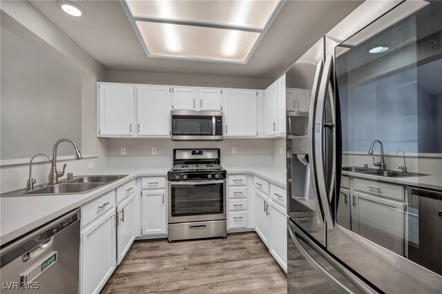 2124 Rising Mist St, Las Vegas, NV 89134 - kitchen featuring appliances with stainless steel finishes, white cabinetry, light wood-style floors, light countertops, and recessed lighting