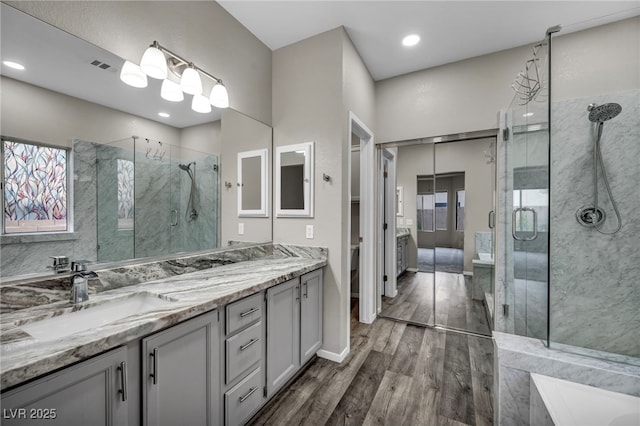 2124 Rising Mist St, Las Vegas, NV 89134 - bathroom featuring a marble finish shower, wood finished floors, vanity, and recessed lighting