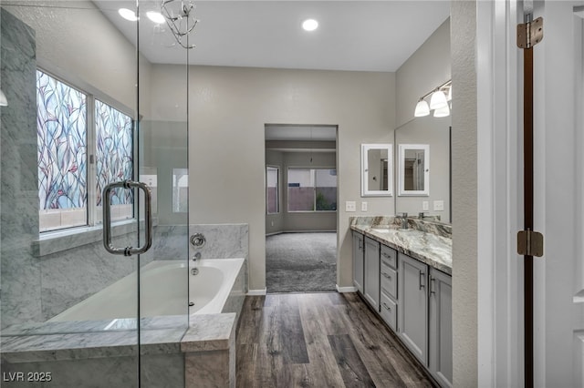 2124 Rising Mist St, Las Vegas, NV 89134 - full bathroom with wood finished floors, double vanity, a garden tub, baseboards, and a chandelier