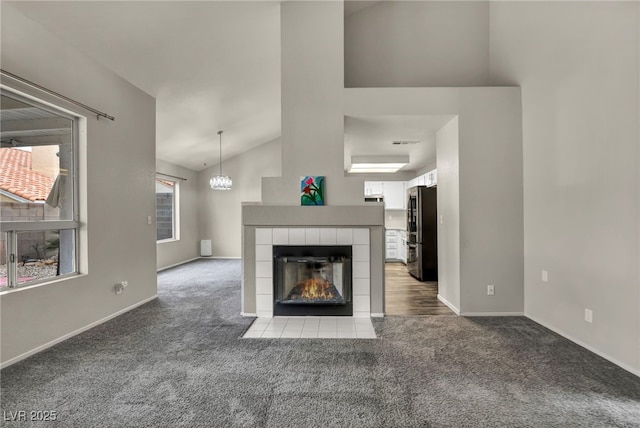 2124 Rising Mist St, Las Vegas, NV 89134 - unfurnished living room featuring carpet floors, a tiled fireplace, and high vaulted ceiling