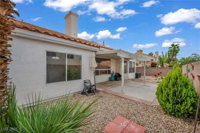 2124 Rising Mist St, Las Vegas, NV 89134 - back of property featuring a fenced backyard, a patio area, a chimney, stucco siding, and a tile roof