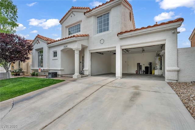 2124 Rising Mist St, Las Vegas, NV 89134 - mediterranean / spanish-style house featuring a tiled roof, secured water heater, concrete driveway, and stucco siding