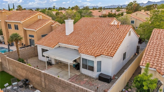 2124 Rising Mist St, Las Vegas, NV 89134 - back of house with a tile roof, a chimney, a fenced backyard, a patio, and stucco siding