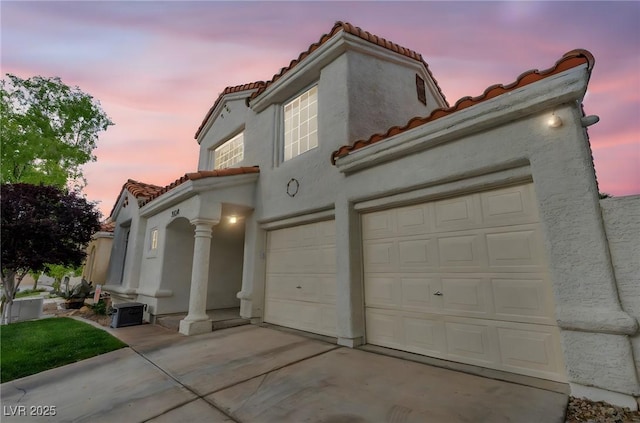 2124 Rising Mist St, Las Vegas, NV 89134 - view of front of house featuring a tile roof, stucco siding, driveway, and an attached garage