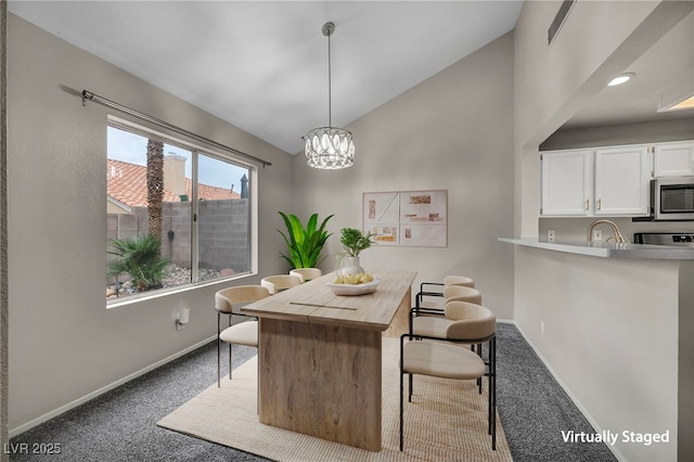 2124 Rising Mist St, Las Vegas, NV 89134 - carpeted dining room with vaulted ceiling, baseboards, and a chandelier