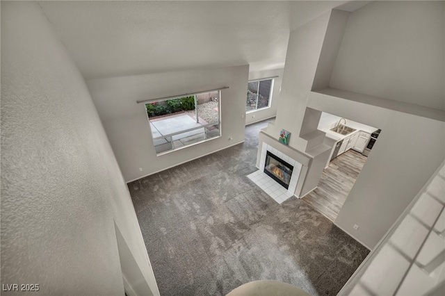 2124 Rising Mist St, Las Vegas, NV 89134 - living area with a fireplace, carpet, baseboards, and lofted ceiling