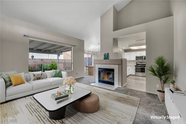 2124 Rising Mist St, Las Vegas, NV 89134 - living area with a fireplace, light colored carpet, baseboards, and a towering ceiling