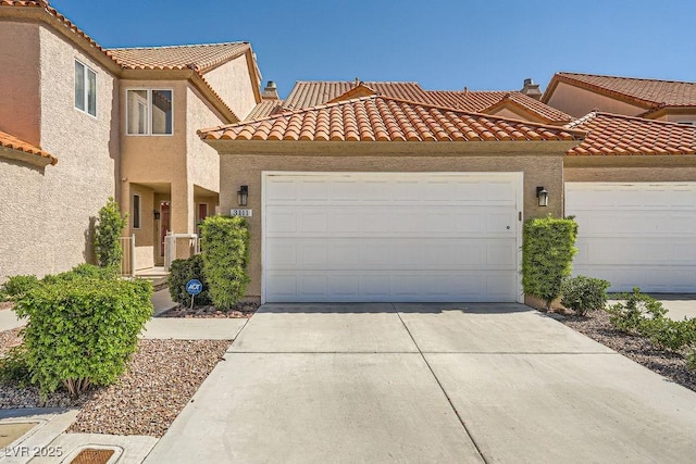 view of front of house featuring concrete driveway, an attached garage, stucco siding, and a tile roof