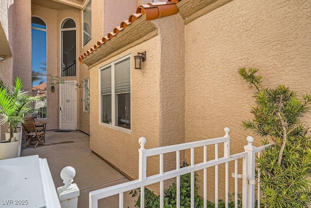 view of side of property with stucco siding and a tile roof