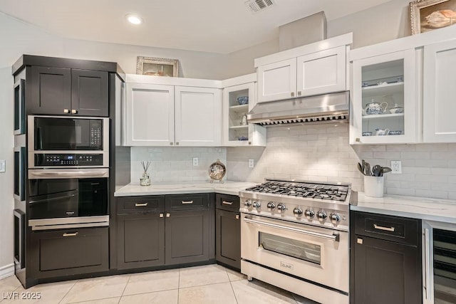 kitchen featuring stainless steel appliances, wine cooler, under cabinet range hood, white cabinetry, and decorative backsplash