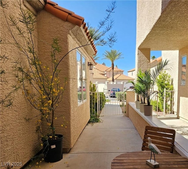 view of home's exterior featuring stucco siding, a residential view, and a gate