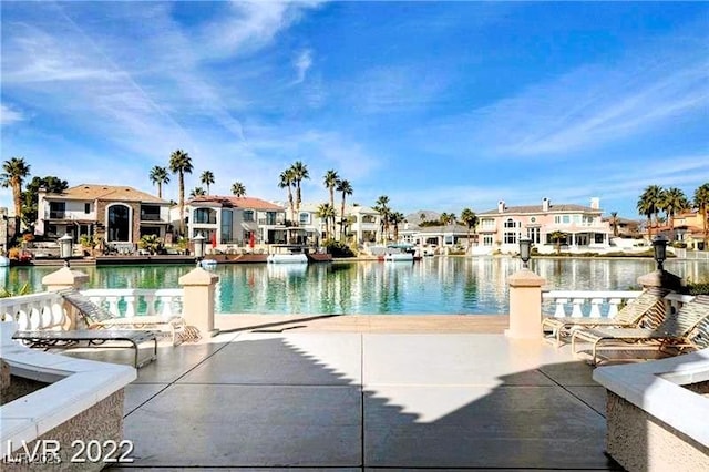 view of swimming pool with a residential view and a water view