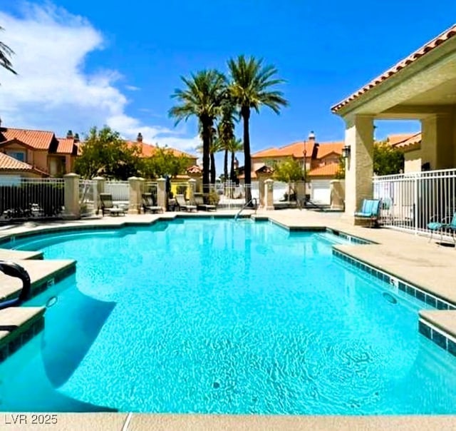 community pool featuring fence and a patio