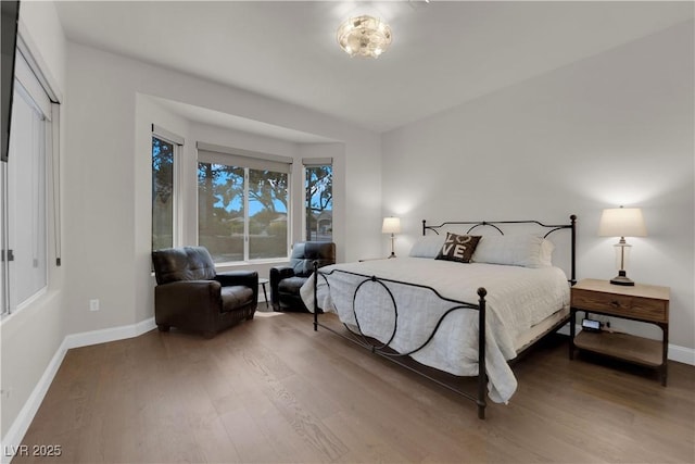 bedroom with wood finished floors and baseboards