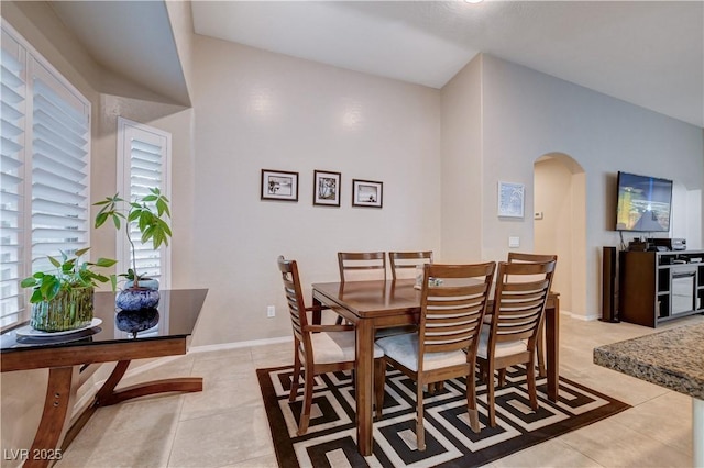 3712 Rocklin Peak Ave, North Las Vegas, NV 89081 - dining room with arched walkways, light tile patterned floors, and baseboards