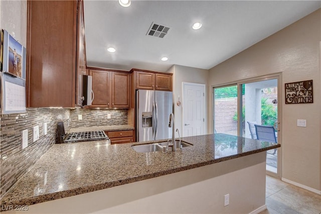 3712 Rocklin Peak Ave, North Las Vegas, NV 89081 - kitchen featuring appliances with stainless steel finishes, a peninsula, vaulted ceiling, backsplash, and dark stone countertops