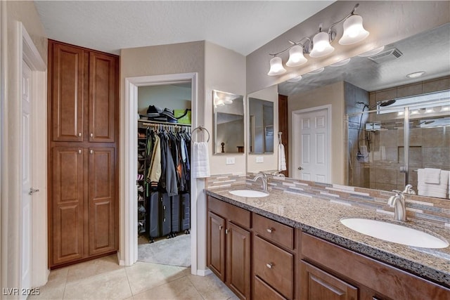 3712 Rocklin Peak Ave, North Las Vegas, NV 89081 - full bath featuring a stall shower, tile patterned flooring, double vanity, a spacious closet, and a textured ceiling
