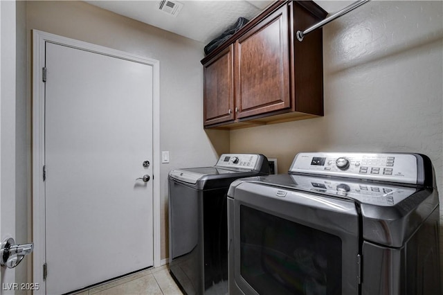3712 Rocklin Peak Ave, North Las Vegas, NV 89081 - laundry area with washer and clothes dryer, cabinet space, and light tile patterned flooring