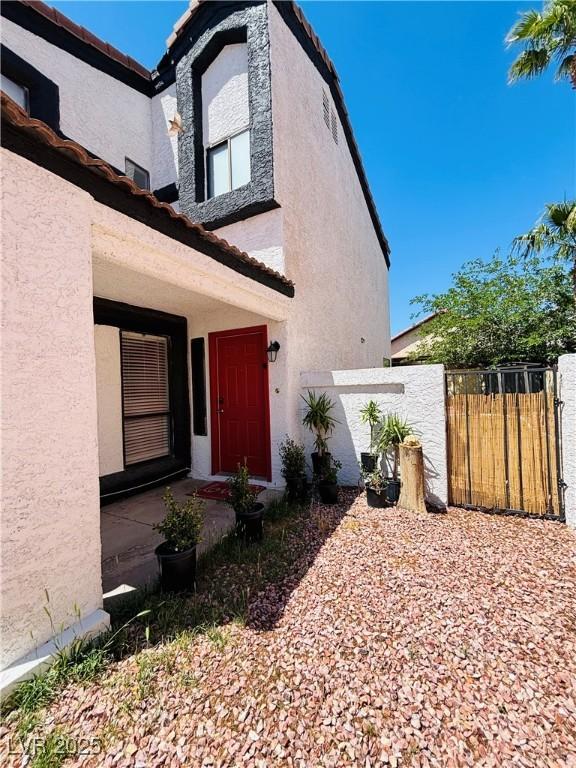 entrance to property with stucco siding and fence