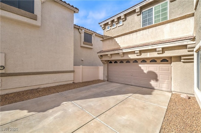 1324 Spice Ridge Ct, Henderson, NV 89012 - view of front of house featuring an attached garage, stucco siding, driveway, and fence