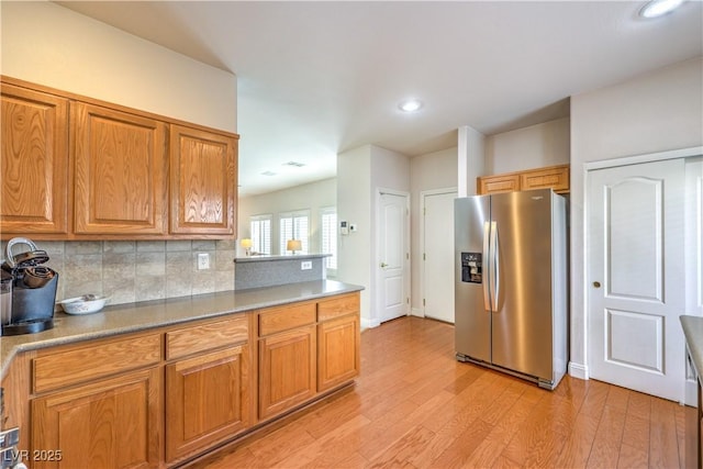 1324 Spice Ridge Ct, Henderson, NV 89012 - kitchen featuring stainless steel fridge, light wood-style floors, brown cabinetry, tasteful backsplash, and recessed lighting