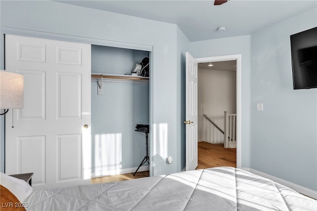 bedroom with wood finished floors and a closet
