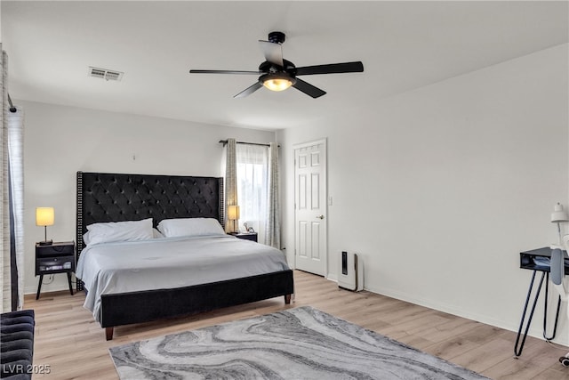 bedroom featuring light wood finished floors, baseboards, and ceiling fan