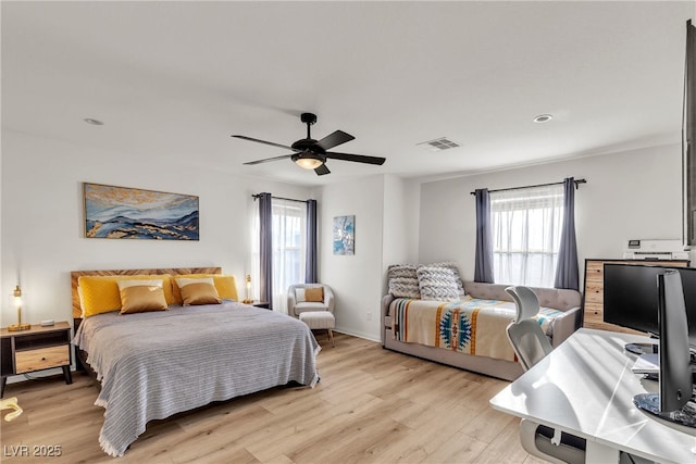 bedroom with multiple windows, light wood-style flooring, and a ceiling fan