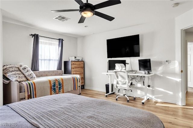 bedroom featuring baseboards, wood finished floors, a ceiling fan, and an office area