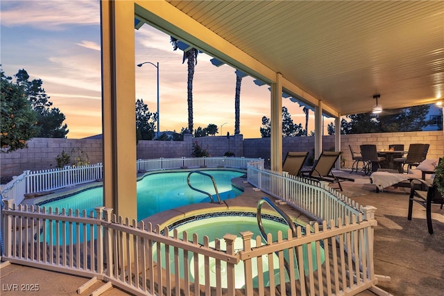view of pool with an in-ground hot tub, a fenced backyard, a patio, and outdoor dining area