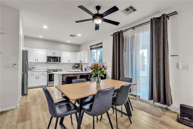 dining room featuring a ceiling fan, light wood finished floors, recessed lighting, and baseboards