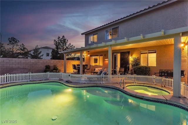 pool at dusk featuring an in-ground hot tub, a fenced backyard, a patio area, and outdoor dining space
