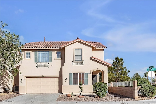mediterranean / spanish-style house with a tile roof, an attached garage, driveway, fence, and stucco siding