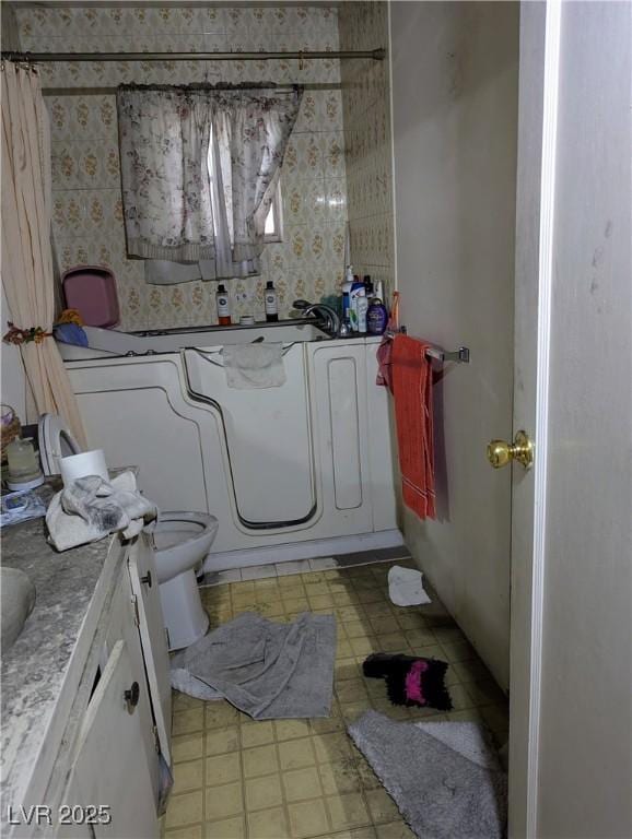 bathroom featuring tile patterned floors, vanity, toilet, a bath, and curtained shower