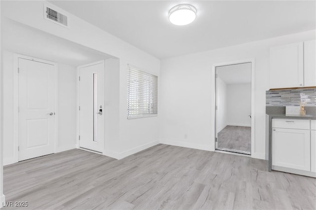 unfurnished living room featuring light wood finished floors and baseboards