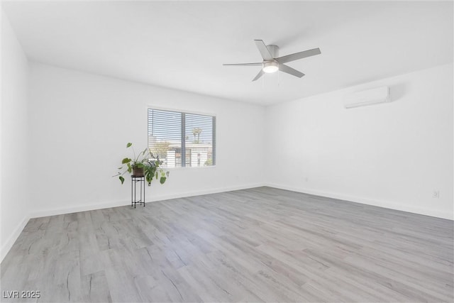 empty room featuring ceiling fan, wood finished floors, a wall mounted air conditioner, and baseboards