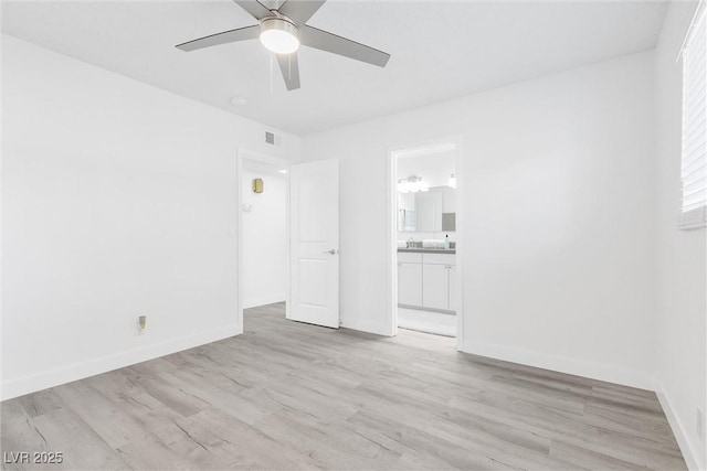 unfurnished bedroom with light wood-style flooring, baseboards, ensuite bathroom, and ceiling fan