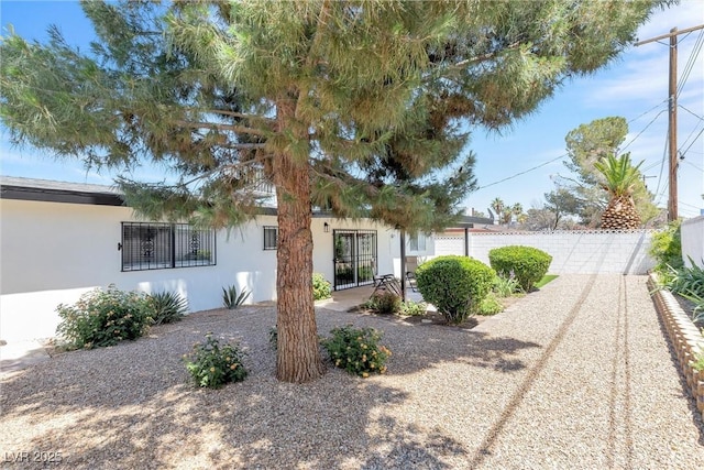 view of front facade featuring stucco siding and fence