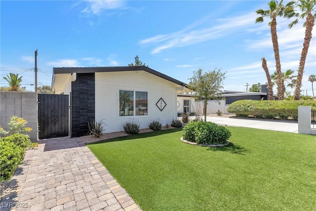 ranch-style home with a gate and stucco siding