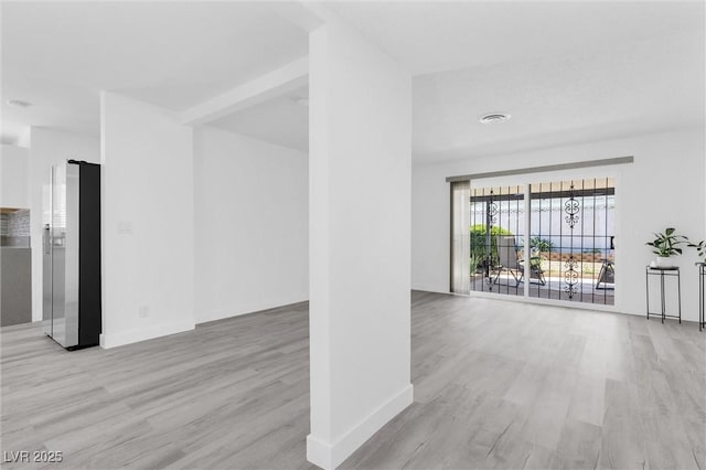unfurnished living room with wood finished floors and baseboards