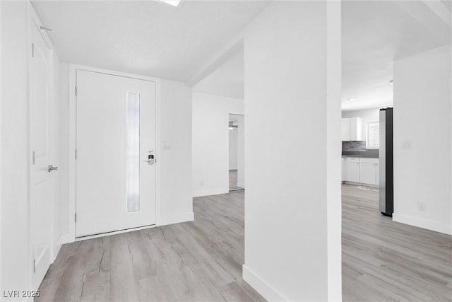 entryway featuring light wood finished floors and baseboards