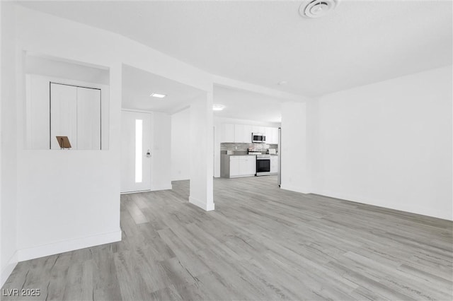 unfurnished living room featuring light wood-style floors and baseboards