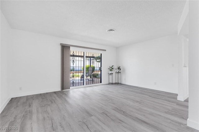 spare room featuring wood finished floors and baseboards