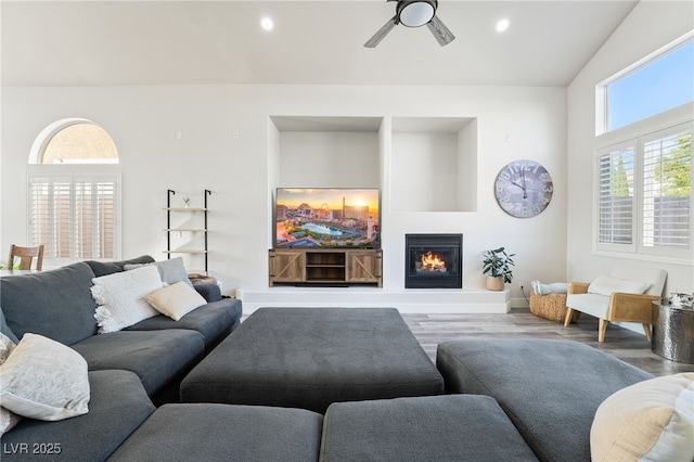 5684 Benevento Ct, Las Vegas, NV 89141 - living room featuring wood finished floors, ceiling fan, a glass covered fireplace, and recessed lighting