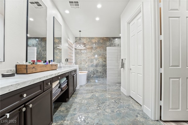 5684 Benevento Ct, Las Vegas, NV 89141 - full bathroom featuring walk in shower, double vanity, tile walls, marble tiled flooring, and a soaking tub