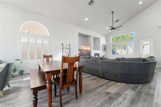 5684 Benevento Ct, Las Vegas, NV 89141 - dining space featuring wood finished floors, a ceiling fan, high vaulted ceiling, a glass covered fireplace, and recessed lighting