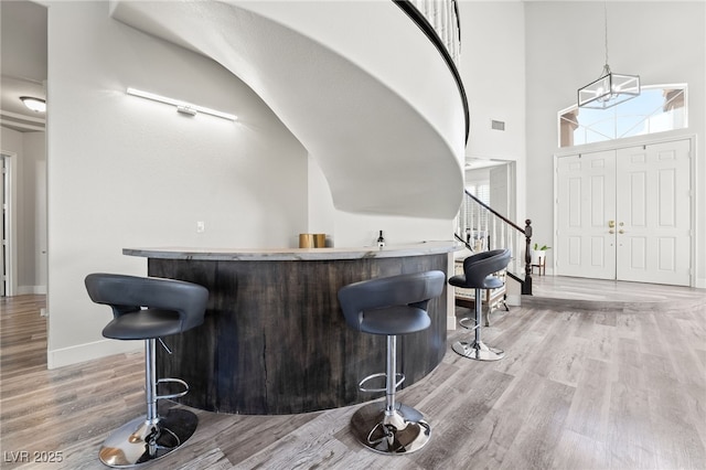 5684 Benevento Ct, Las Vegas, NV 89141 - indoor bar featuring light wood-style floors, stairs, baseboards, and decorative light fixtures