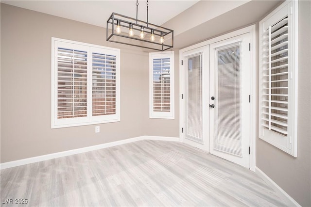 unfurnished dining area featuring french doors, wood finished floors, and baseboards